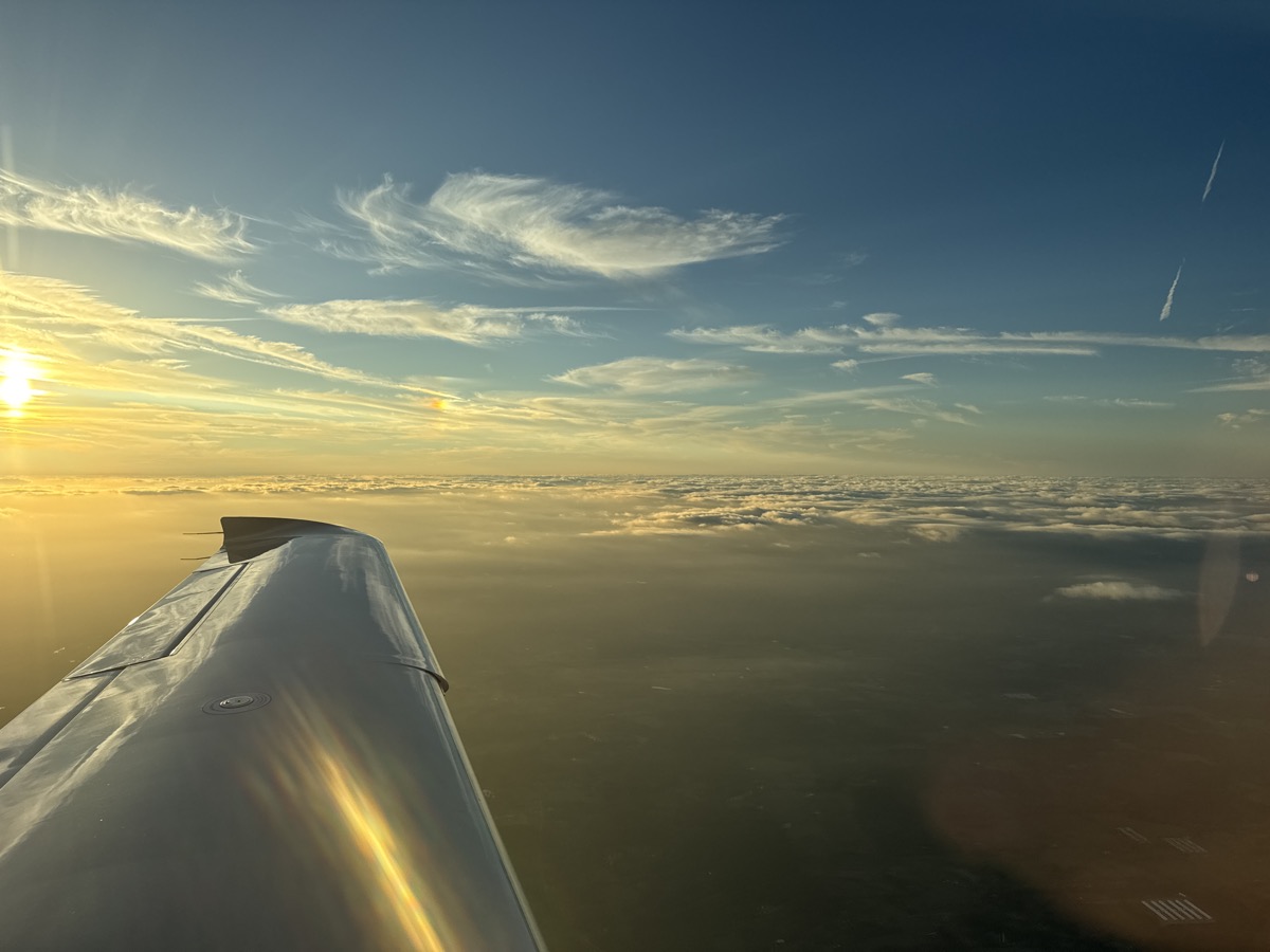 Wing above the clouds at sunset